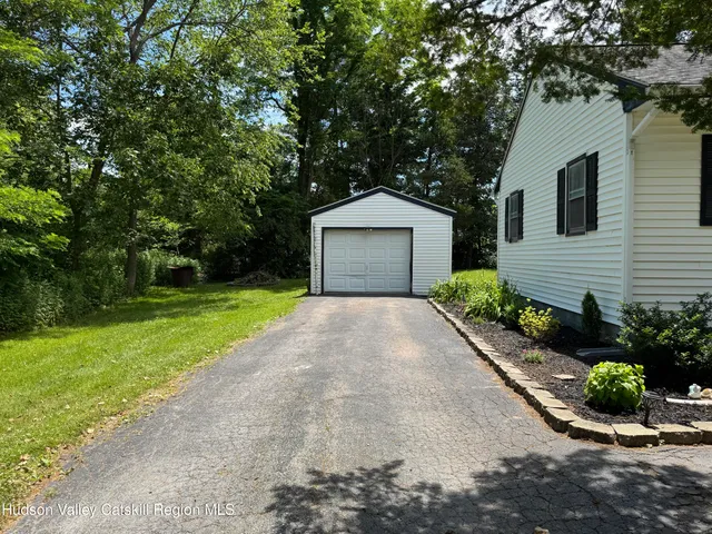 a front view of a house with a yard and potted plants