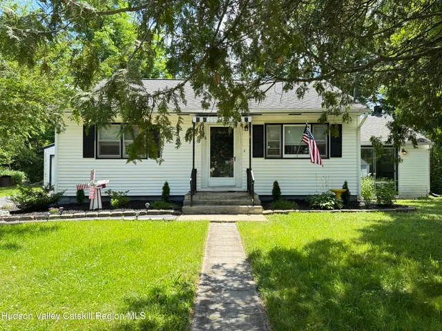 a front view of house with yard and outdoor seating