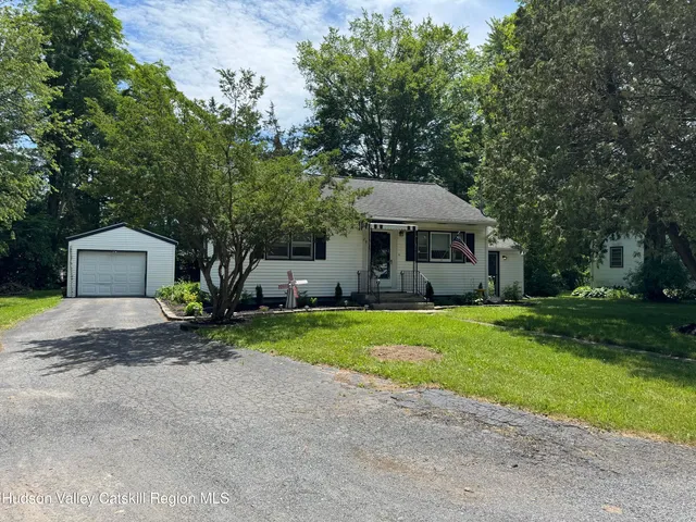 a front view of a house with a yard and green space