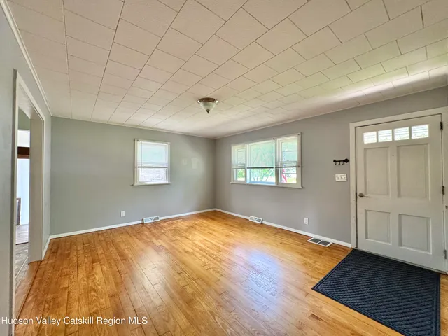 a view of empty room with wooden floor
