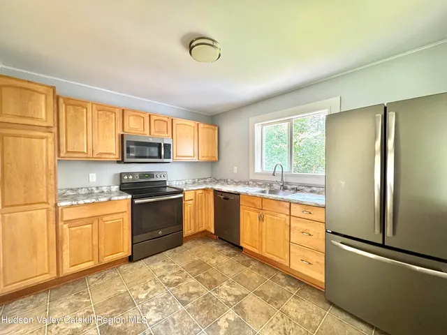 a kitchen with stainless steel appliances granite countertop a refrigerator sink and stove