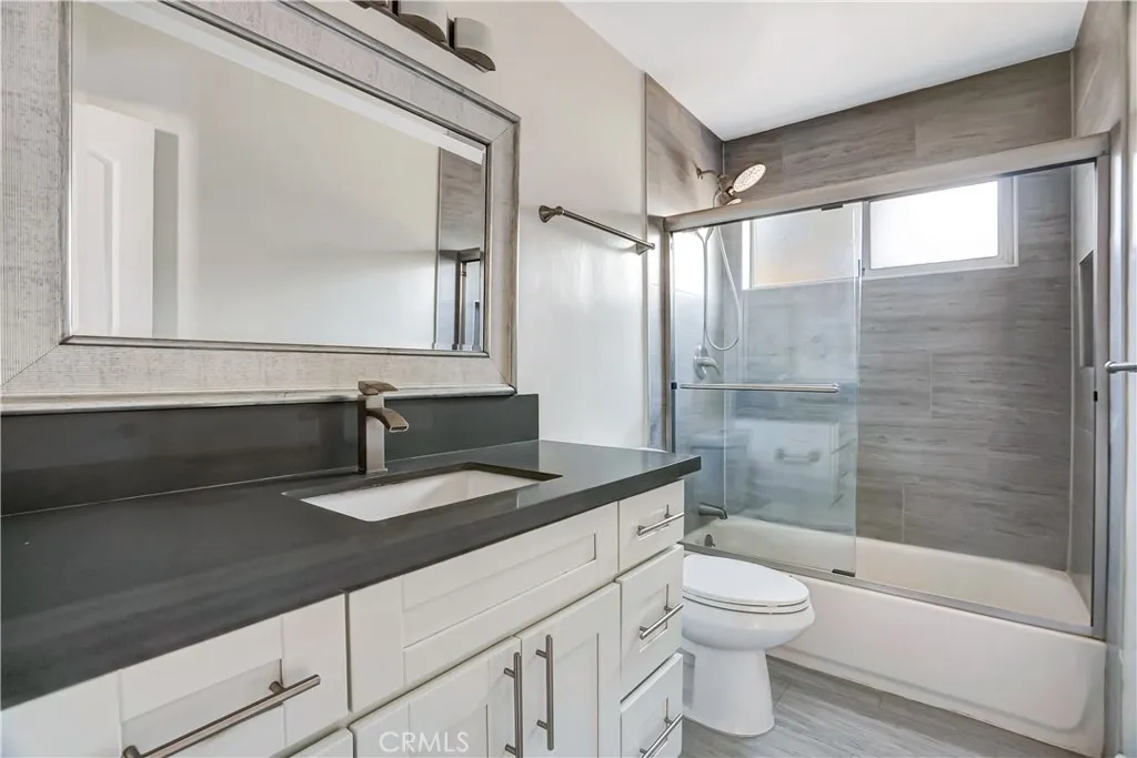 6520 Shirley Reseda, CA 91335 - Photo 9 of 26 a bathroom with a granite countertop sink toilet a mirror and shower