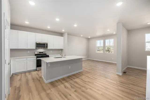 a large kitchen with kitchen island a sink stainless steel appliances and cabinets