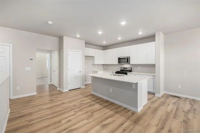 a view of kitchen with granite countertop cabinets and refrigerator