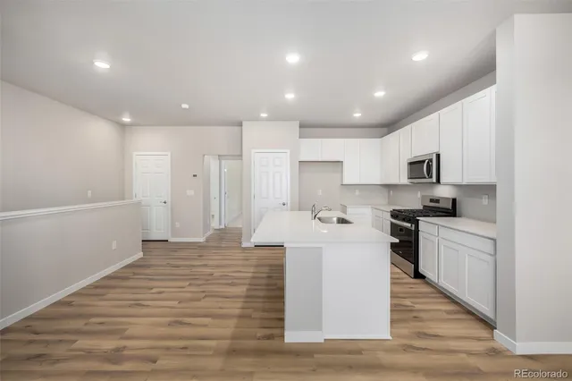 a large kitchen with kitchen island a sink stainless steel appliances and cabinets