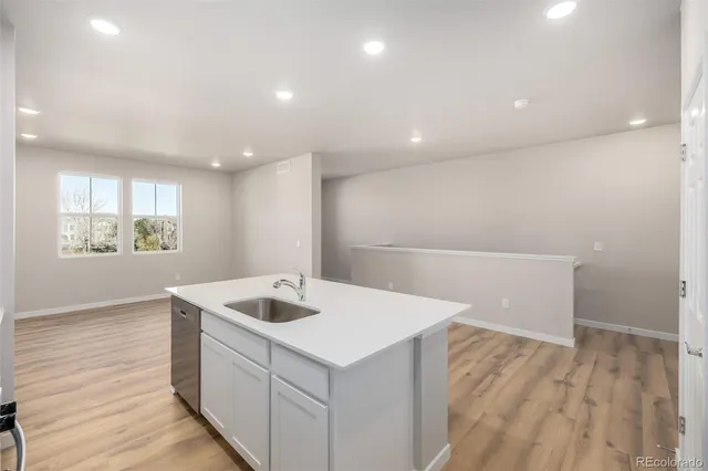 a kitchen with a sink cabinets and wooden floor