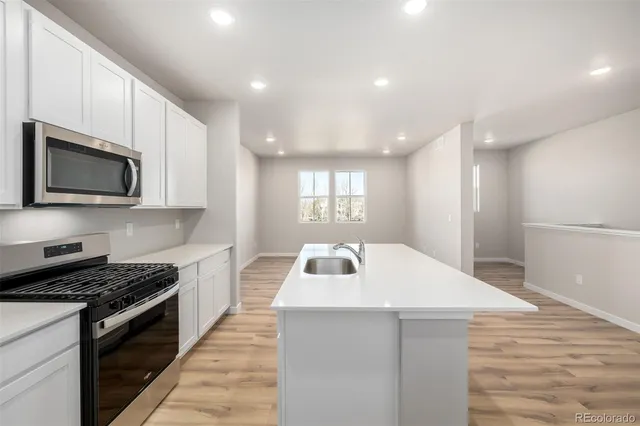 a kitchen with kitchen island a sink stainless steel appliances and cabinets