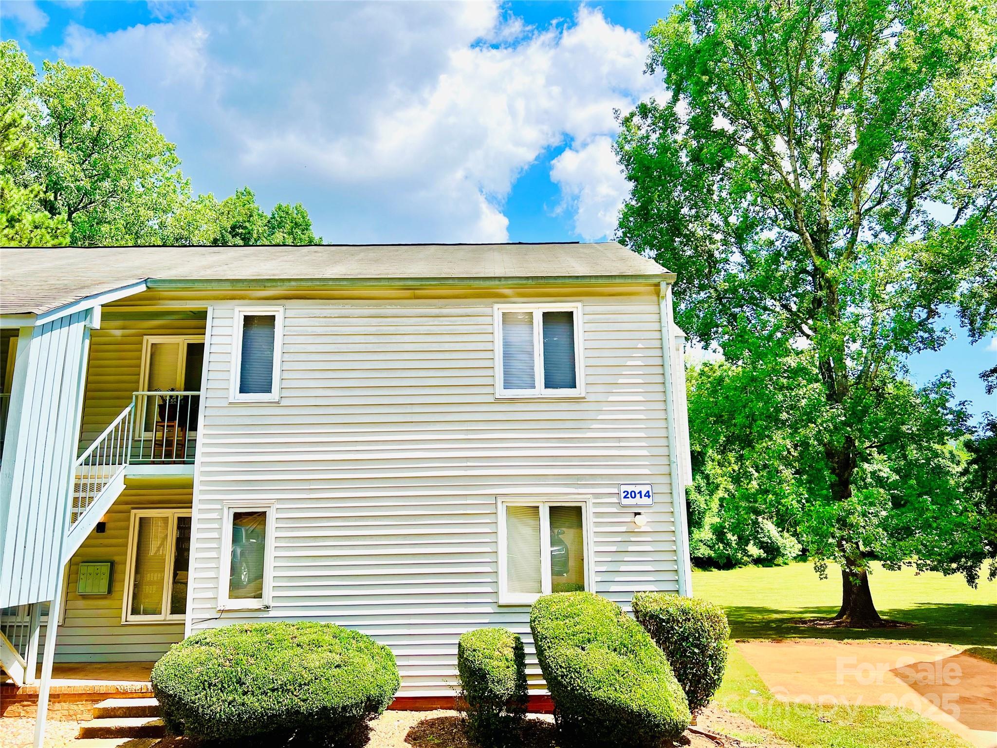 2014 Countrymens Court, Unit 60 Charlotte, NC 28210 - Photo 1 of 9 a view of a backyard with plants and a large tree