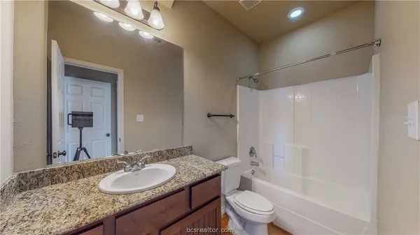a bathroom with a granite countertop sink toilet and shower