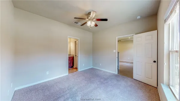 a view of an empty room and a ceiling fan