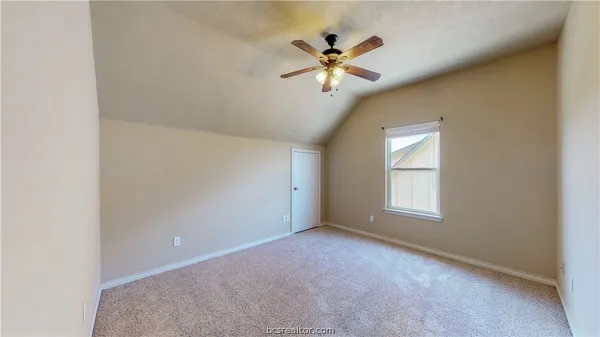 an empty room with windows and chandelier fan