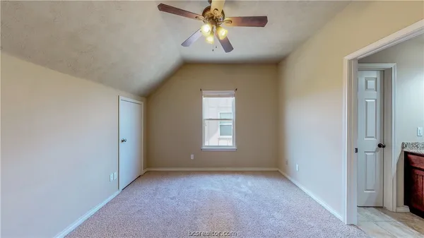 a view of empty room with window and chandelier fan