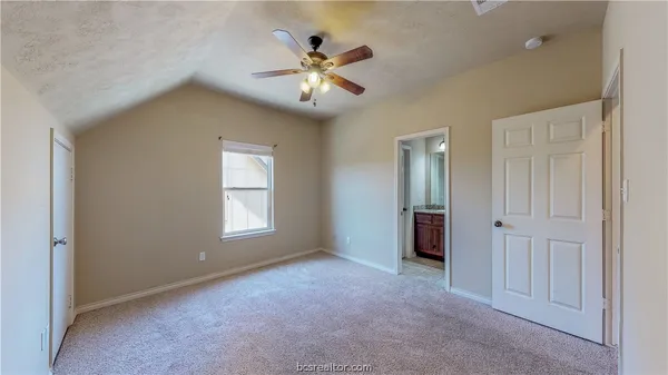 a view of an empty room with window and chandelier fan