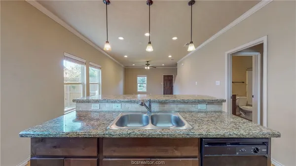 a bathroom with a granite countertop sink and a window