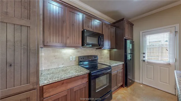 a kitchen with granite countertop cabinets stainless steel appliances and a counter space