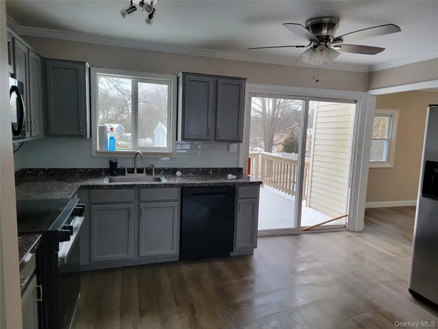 a kitchen with granite countertop a stove a sink and a refrigerator