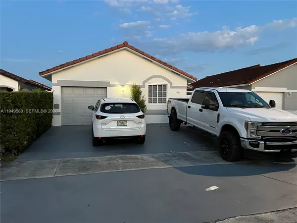 a white car parked in front of a house