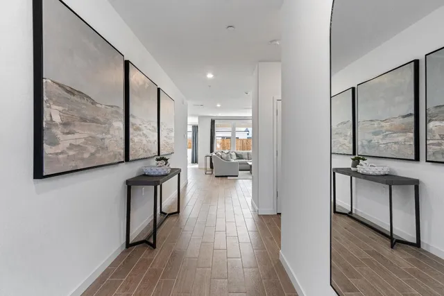 a view of a hallway with wooden floor and furniture