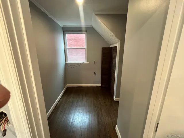 a view of hallway with wooden floor and window