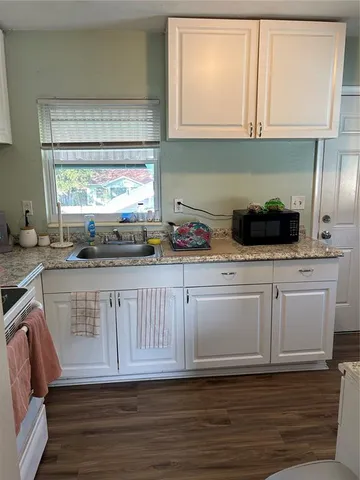 a kitchen with white cabinets a sink and appliances