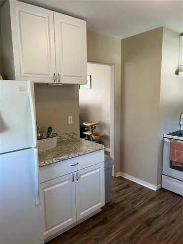 a kitchen with a sink cabinets and wooden floor