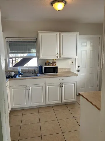 a kitchen with white cabinets and white appliances