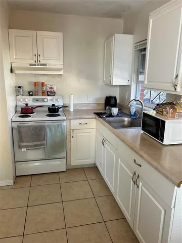a kitchen with cabinets appliances a sink and a counter top space