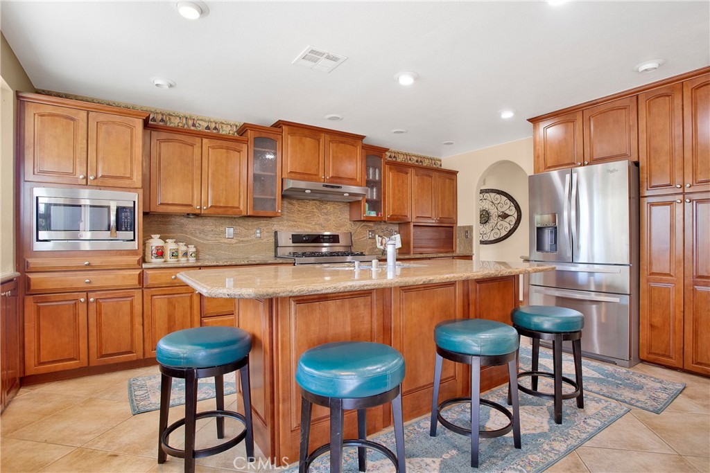 9275 Rattlesnake Road Phelan, CA 92371 - Photo 3 of 68 a kitchen with stainless steel appliances a table chairs refrigerator and a sink