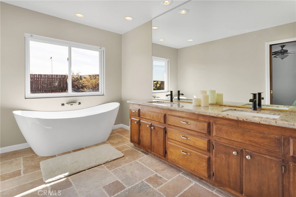 9275 Rattlesnake Road Phelan, CA 92371 - Photo 34 of 68 a spacious bathroom with a tub double sink and mirror