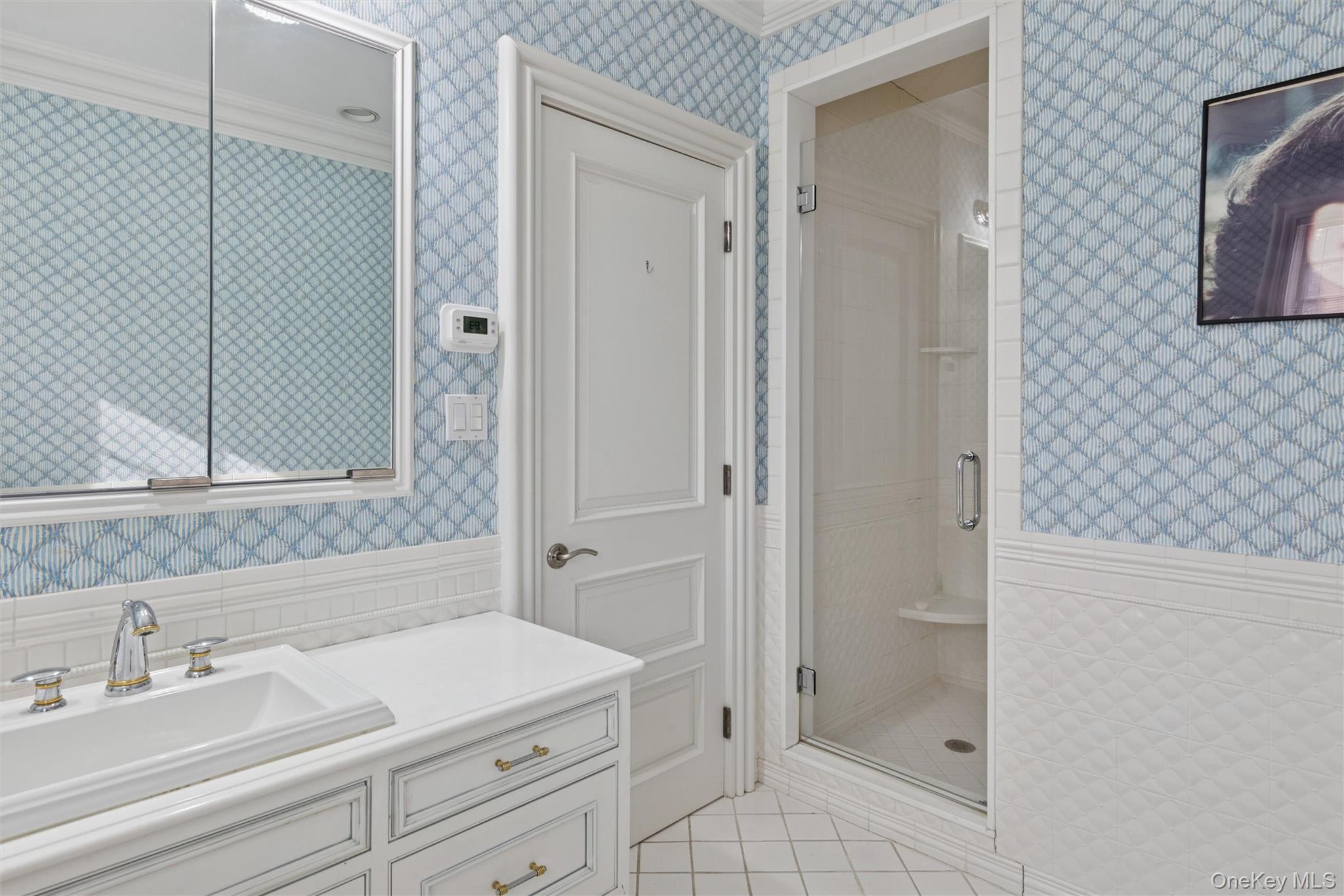 22 Willow Road Woodmere, NY 11598 - Photo 16 of 27 a bathroom with a sink a mirror and a shower