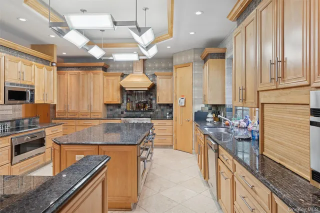 a kitchen with stainless steel appliances granite countertop a stove a sink and a refrigerator
