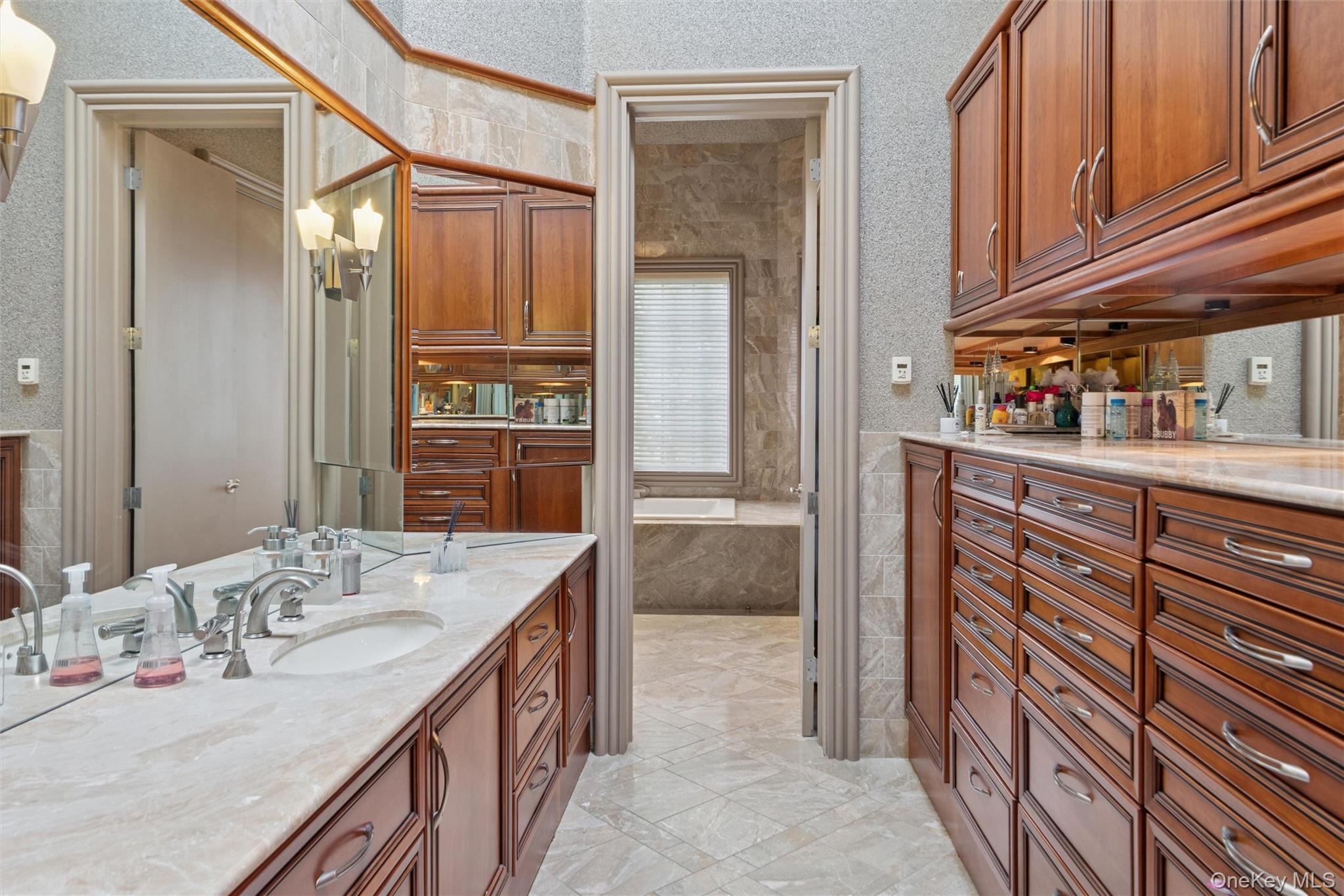22 Willow Road Woodmere, NY 11598 - Photo 10 of 27 a bathroom with a granite countertop sink a mirror and shower