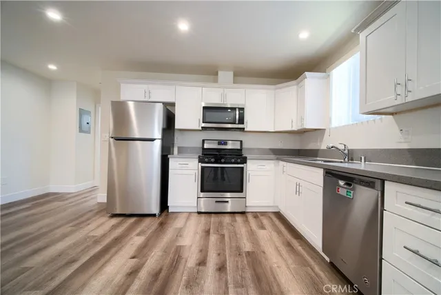 a kitchen with stainless steel appliances a refrigerator sink and microwave