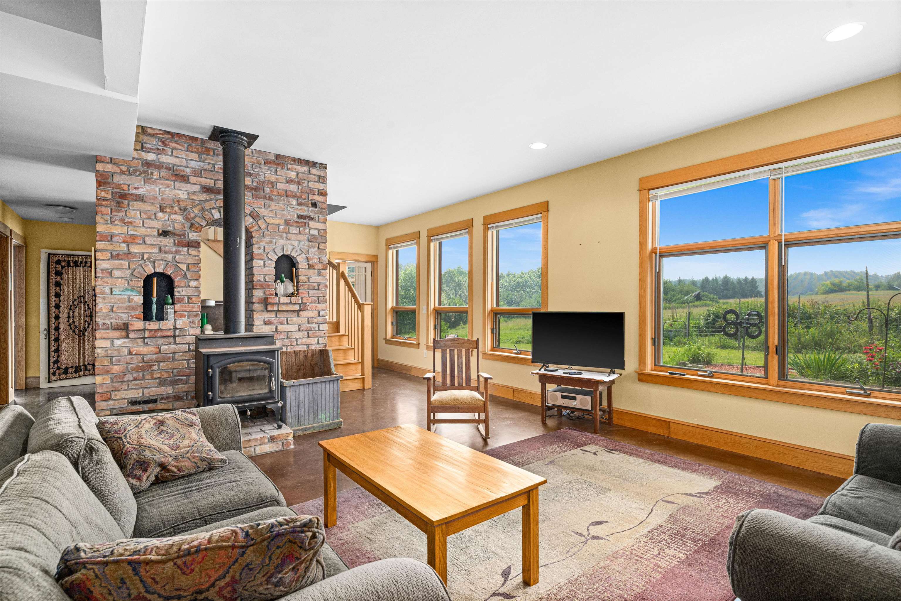 374 Nelson Road Cloquet, MN 55720 - Photo 8 of 33 Living room featuring a wood stove, wood finished floors, plenty of natural light, stairs, and recessed lighting