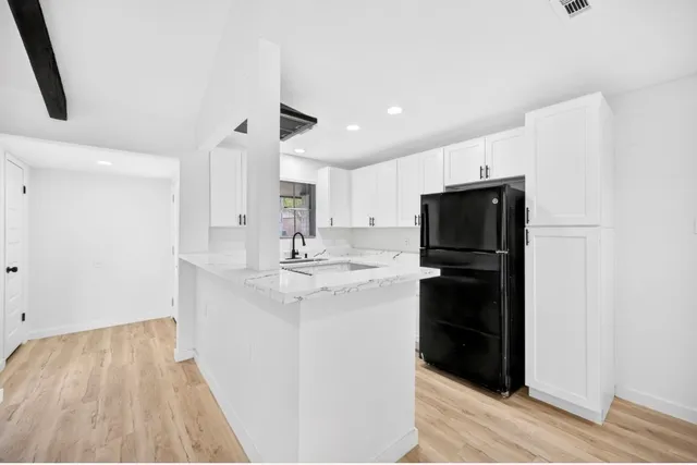 a view of a hallway with wooden floor and staircase