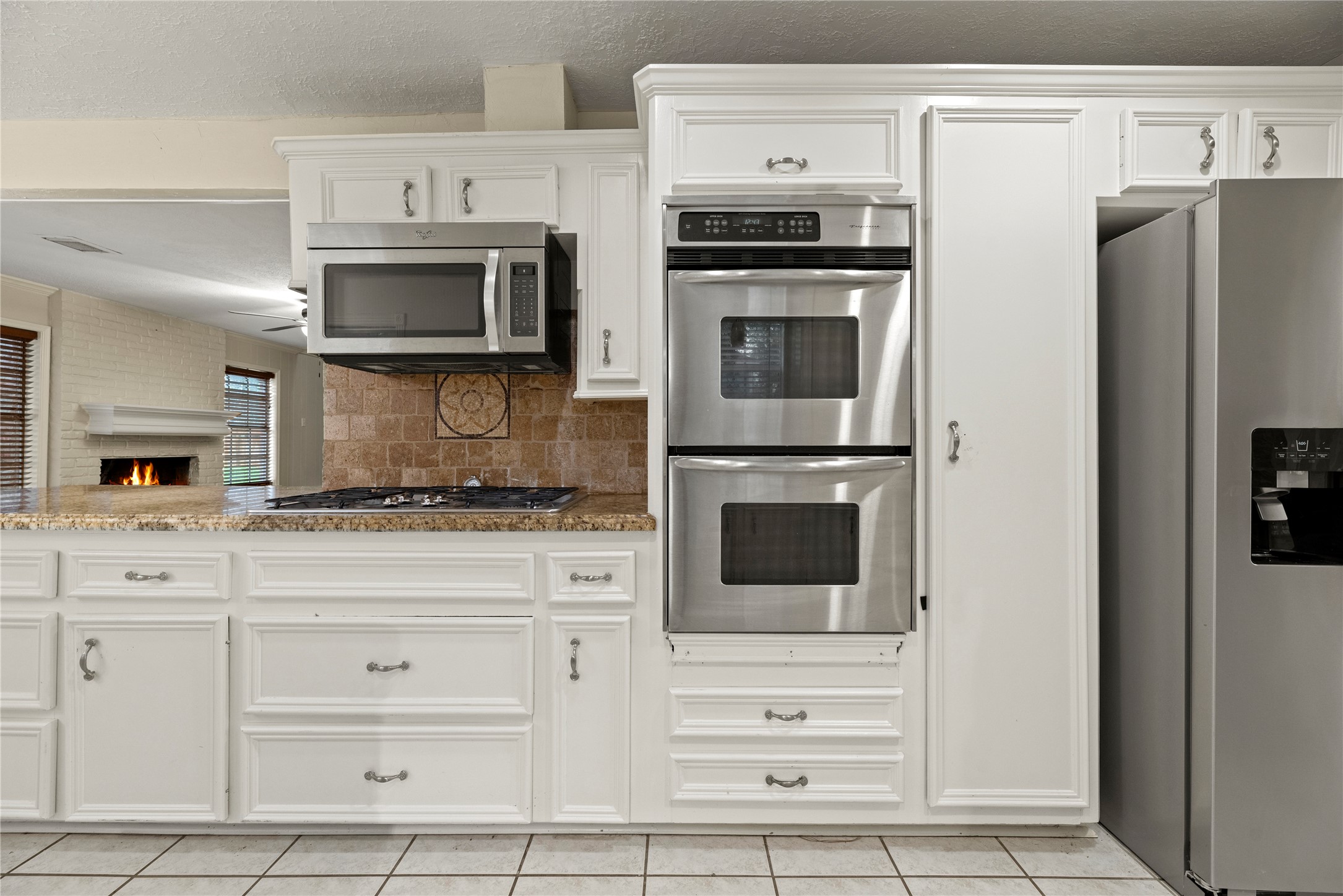 1103 Suwanee Lane Houston, TX 77090 - Photo 5 of 19 The kitchen includes a stainless steel double oven, a built-in microwave, and a professional gas cooktop integrated into the countertops, supporting both everyday meals and larger gatherings.
