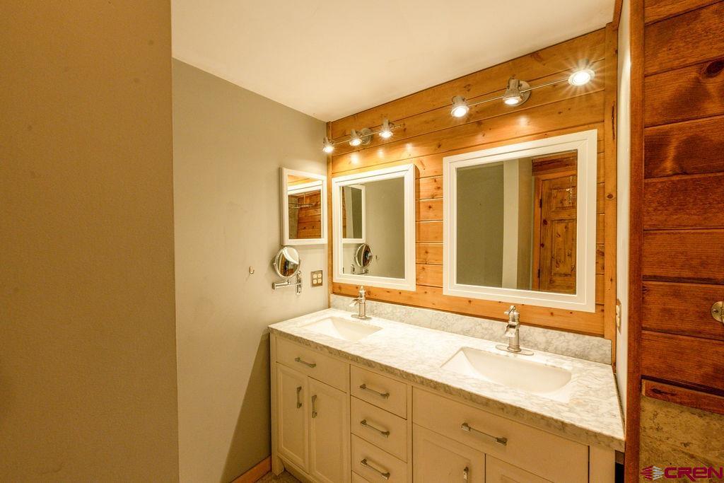 19595 Surface Creek Road Cedaredge, CO 81413 - Photo 14 of 28 a bathroom with a double vanity sink and a mirror