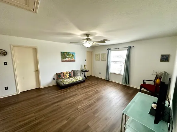 a view of a workspace with wooden floor and a window