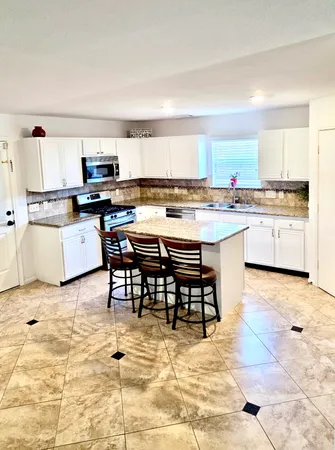a kitchen with a sink and white cabinets