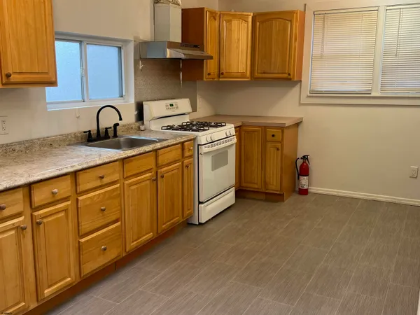 a kitchen with stainless steel appliances granite countertop a sink dishwasher a stove and a microwave oven with cabinets