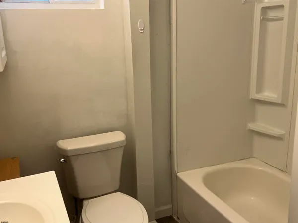 a white toilet sitting next to a white tub