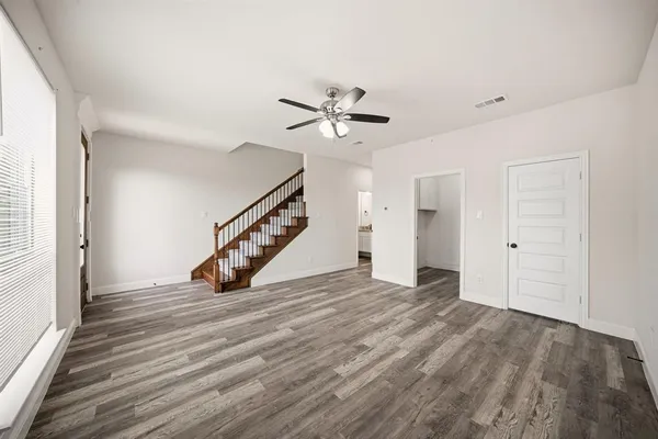 a view of an empty room with a window and a ceiling fan