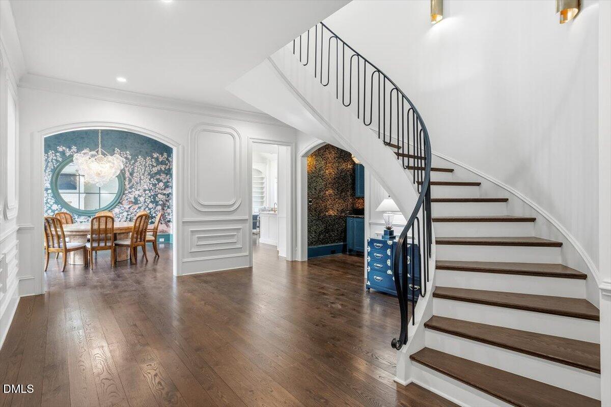 2123 St Marys Street Raleigh, NC 27608 - Photo 2 of 76 a view of staircase and dining room with wooden floor and a chandelier