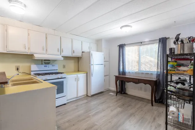 a kitchen with granite countertop white cabinets and white appliances