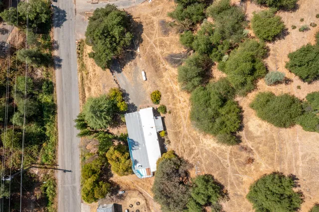 an aerial view of a house with a yard and covered with swimming pool