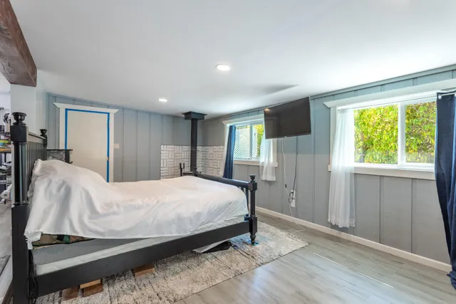 a bedroom with a bed a mirror and a window