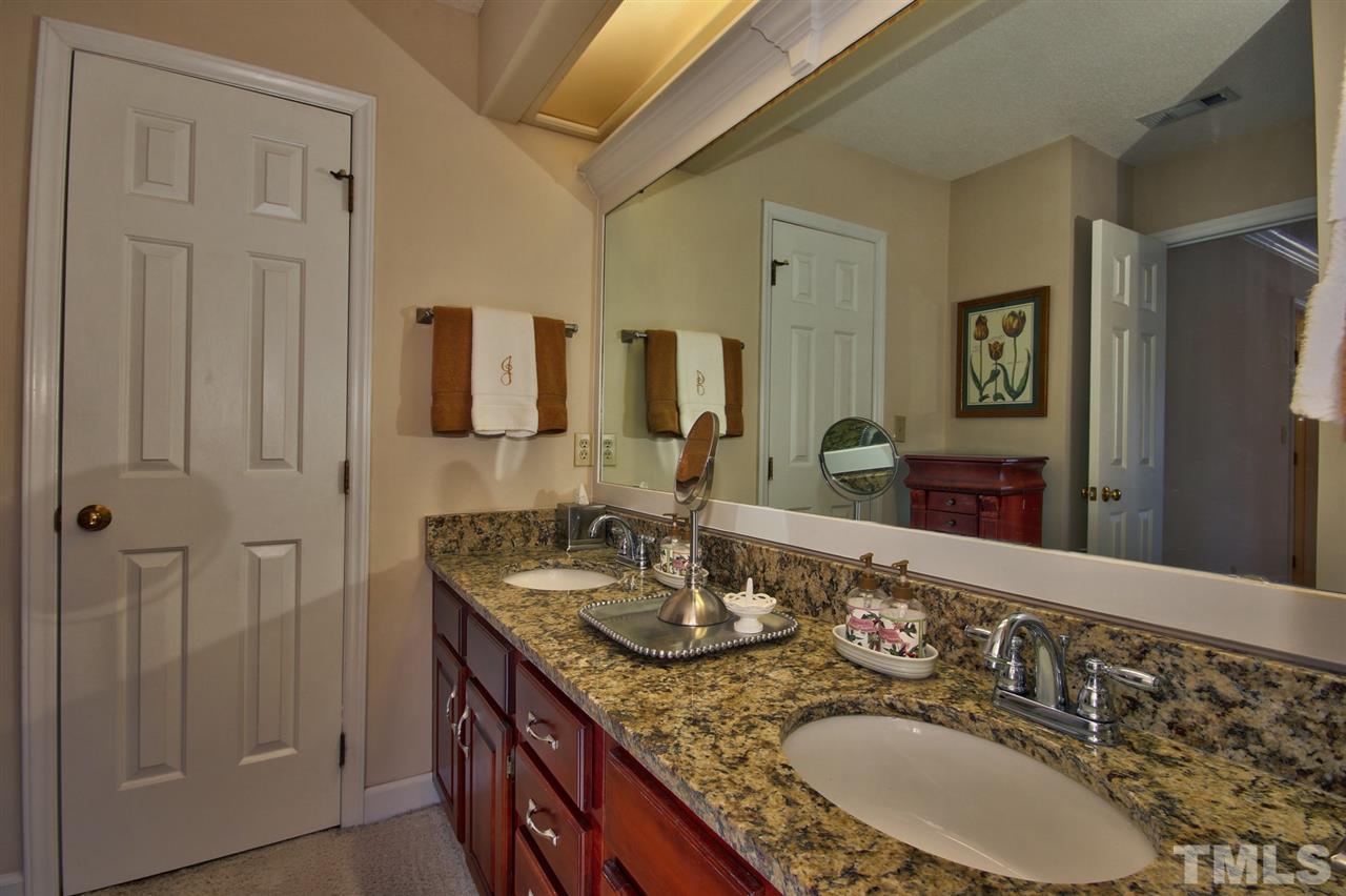 7141 Kinross Drive Raleigh, NC 27613 - Photo 12 of 19 a bathroom with double vanity sinks a mirror and a shower
