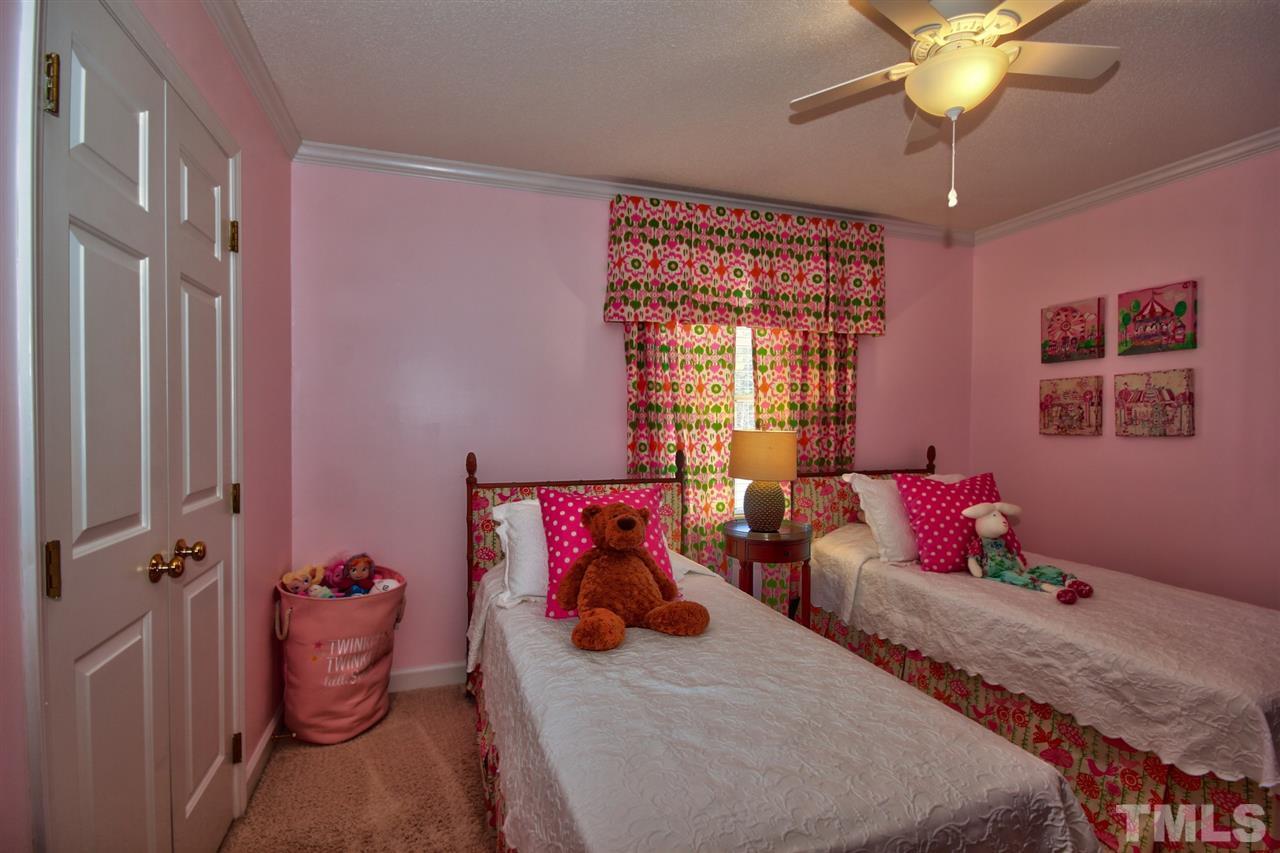 7141 Kinross Drive Raleigh, NC 27613 - Photo 14 of 19 a bedroom with furniture and a chandelier