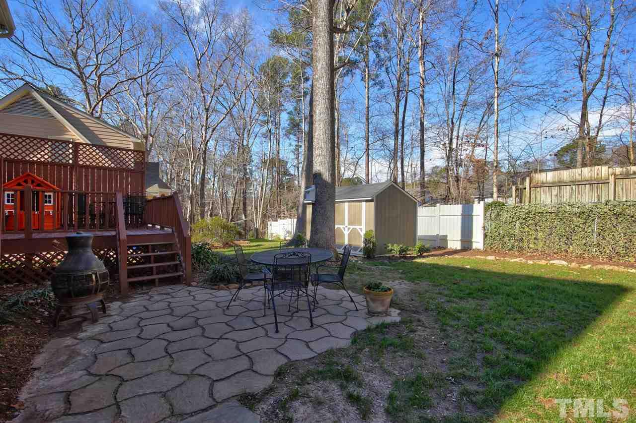 7141 Kinross Drive Raleigh, NC 27613 - Photo 18 of 19 a backyard of a house with barbeque oven and outdoor seating