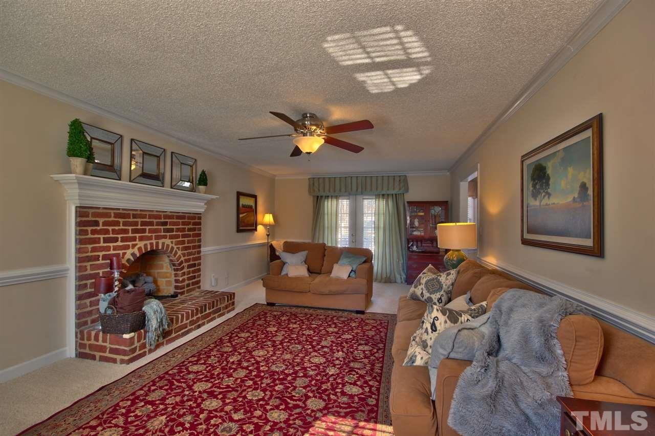 7141 Kinross Drive Raleigh, NC 27613 - Photo 4 of 19 a living room with furniture chandelier and a fireplace